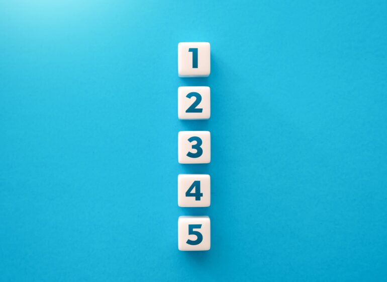 5 Würfel mit den Zahlen 1 bis 5 sind senkrecht gestapelt vor blauem Hintergrund