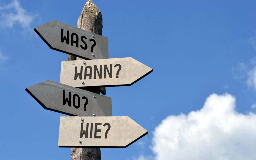 Hinweisschild mit Pfeilen in verschiedene Richtungen: Was? Wann? Wo? wie?