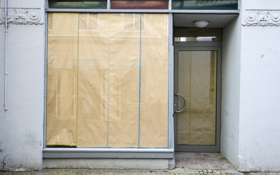 Zugeklebtes Schaufenster wegen Geschäftsaufgabe