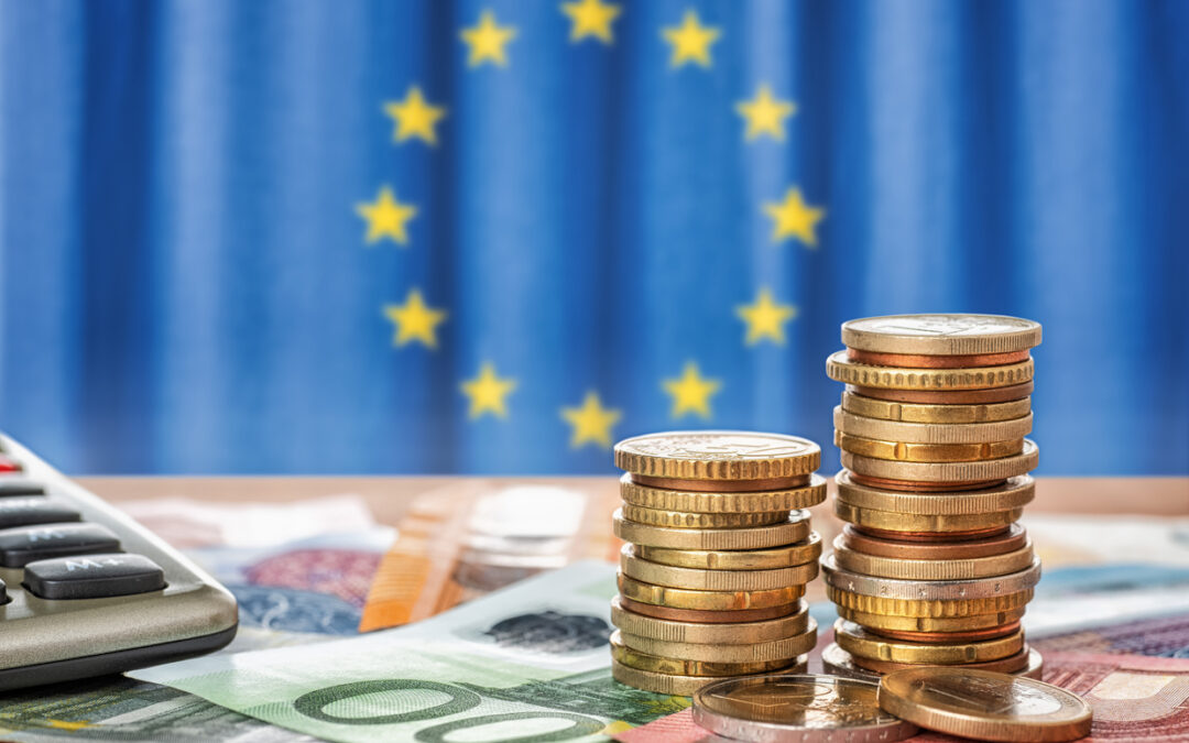 Euronoten, dahinter ein blauer Vorhang mit gelben Sternen der Europaflagge